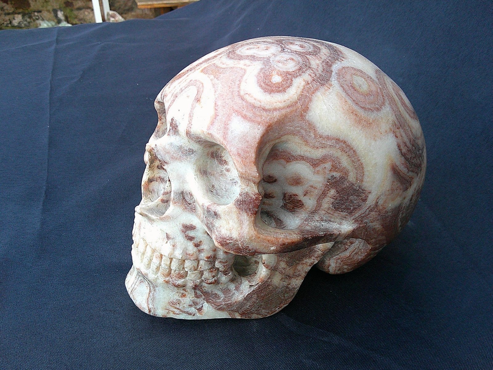 Perspective latérale de “La Madre”, crâne façonné dans une stalagmite d’aragonite révélant les strates minérales déposées au fil du temps.