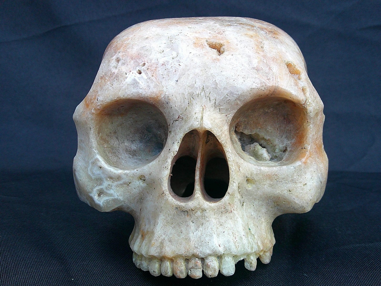 Crâne “Le Caverneux” sculpté dans une agate de la Dourbie, avec mise en valeur des reliefs et de la transparence partielle du minéral.