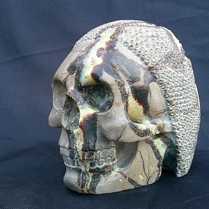 Crâne “Le Guerrier” taillé dans une septaria, mettant en valeur les fissures naturelles du minéral et le motif sculpté évoquant une armure.