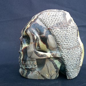 Vue de la sculpture “Le Guerrier” montrant la septaria brute et le travail du crâne sculpté à la main, motif arrière en côte de maille.