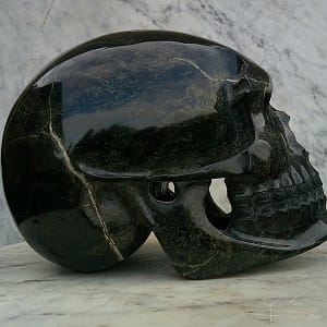 Crâne “Le Reptilien” partiellement évidé, sculpté dans une serpentine du Puy du Wolf avec un poli exceptionnel.