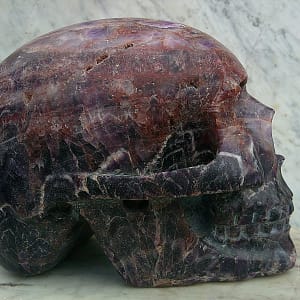 Vue rapprochée du crâne “Vulcain d’Auvergne” révélant la structure chevronnée de l’améthyste et ses nuances de violet.