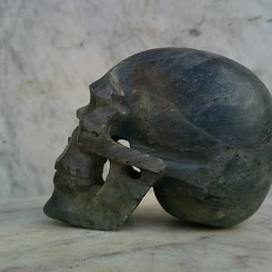 Crâne sculpté en labradorite, vue de profil droit, sculpture minérale taillée et polie à la main, pièce d’art en pierre naturelle.