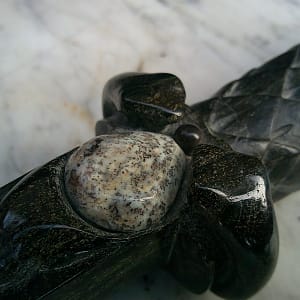 Gros plan sur la merlinite ornant “La Griffe du Dragon”, révélant ses motifs naturels en contraste avec la serpentine.