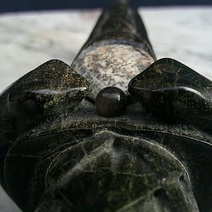 Détail de la perle d’obsidienne montée sur le poignard “La Griffe du Dragon”, avec texture brillante et reliefs sculptés.