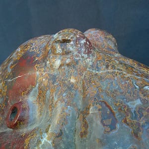 Vue rapprochée du “Kraken”, pieuvre sculptée dans une agate aux teintes rouges claires et zones translucides.