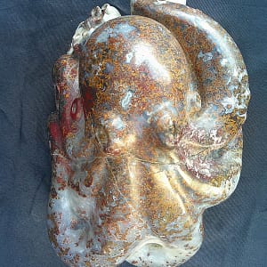 Sculpture artisanale “Kraken”, pieuvre taillée dans une agate rouge aux variations de lumière et transparence naturelles.