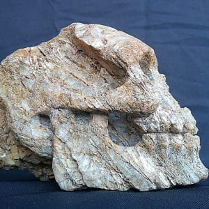 Crâne “Homo Quartzien” taillé dans un quartz d’Aveyron, montrant un travail minimal de poli pour conserver l’aspect pierre brute.